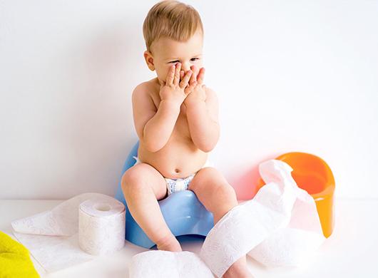photo of a surprised little boy sitting on a potty
